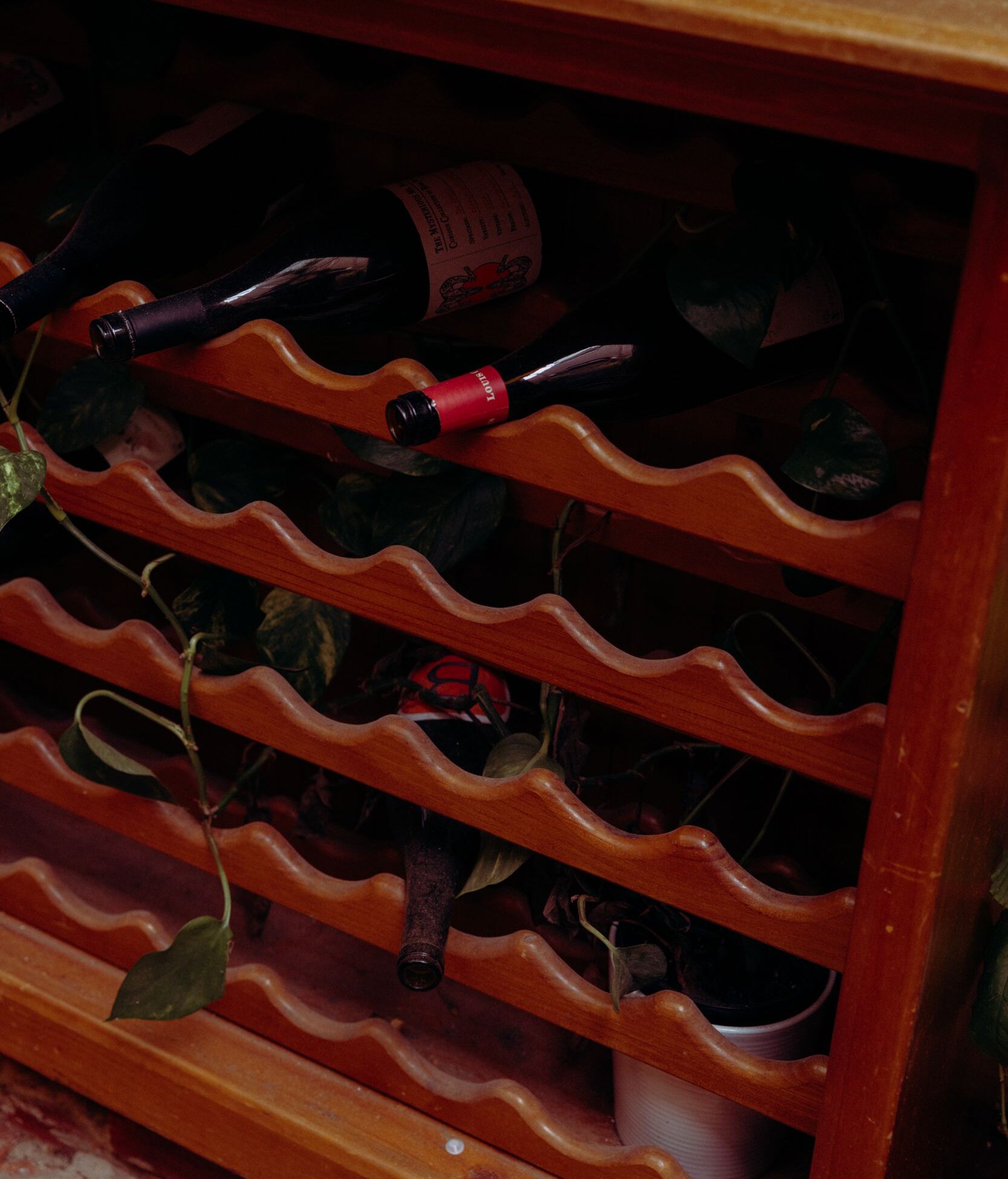 Wine bottles resting on a wooden rack at Nowhere Bar