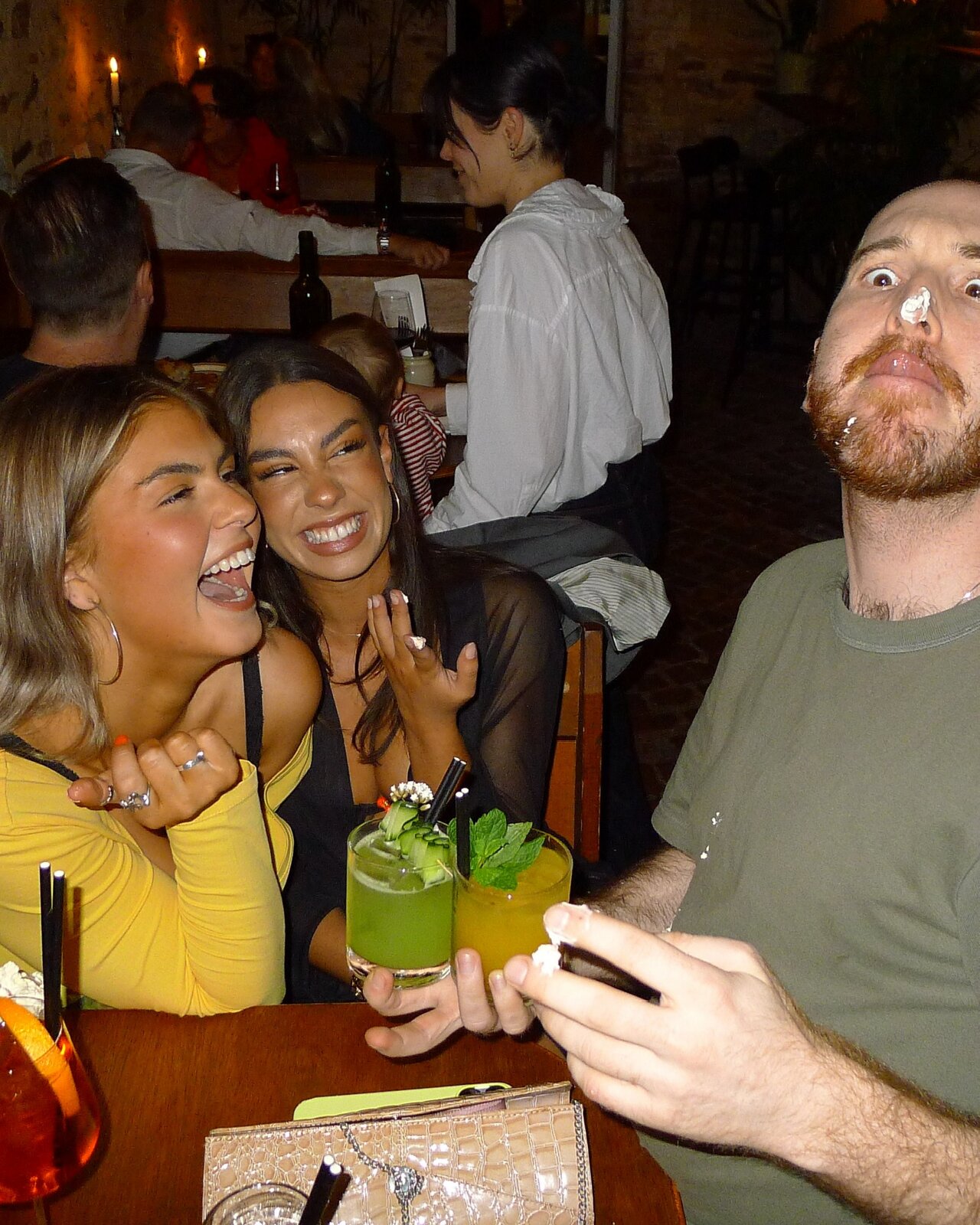 Friends laughing over drinks at Nowhere Bar