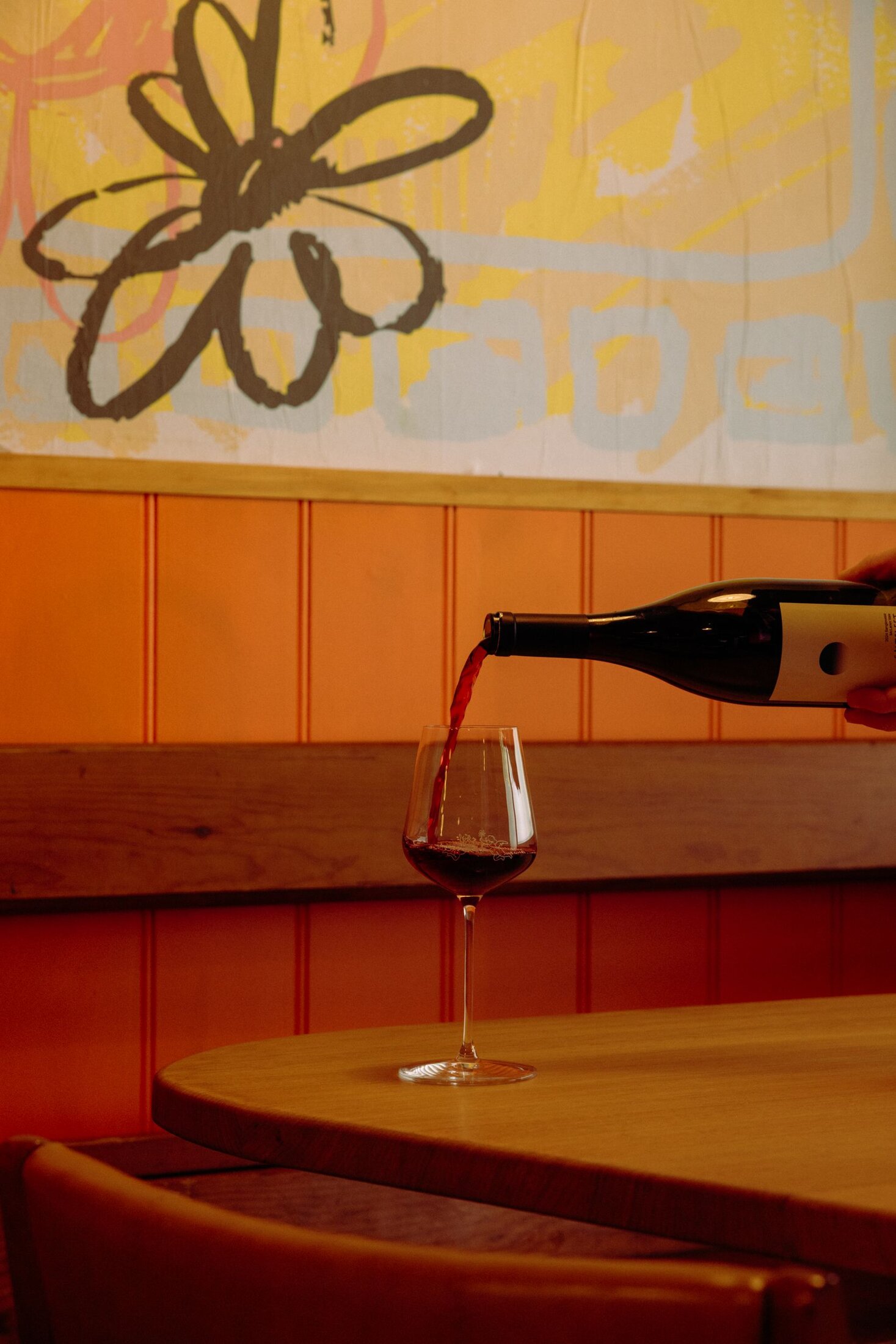 Wine being poured at a table inside Nowhere Bar