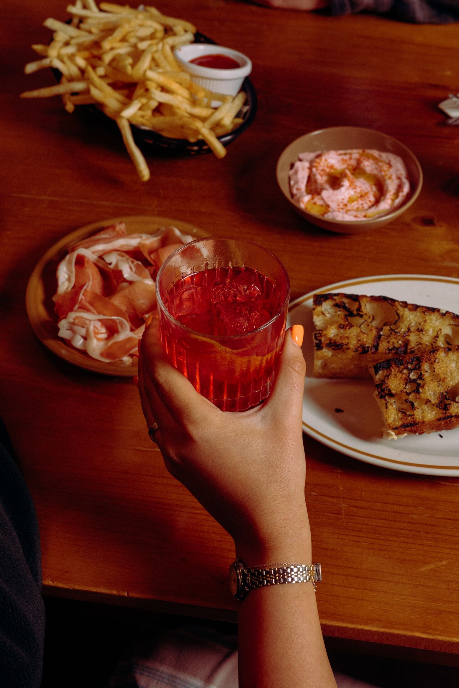 A negroni, prosciutto and grilled bread on the table at Nowhere Bar