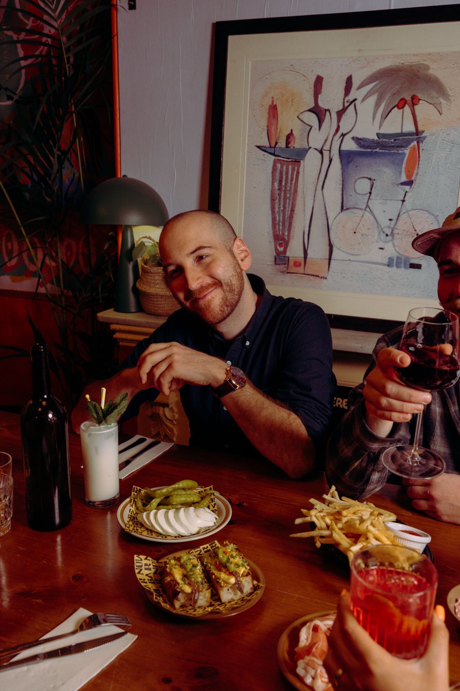 A table at Nowhere Bar mid-celebration — food, wine and cocktails shared around the table